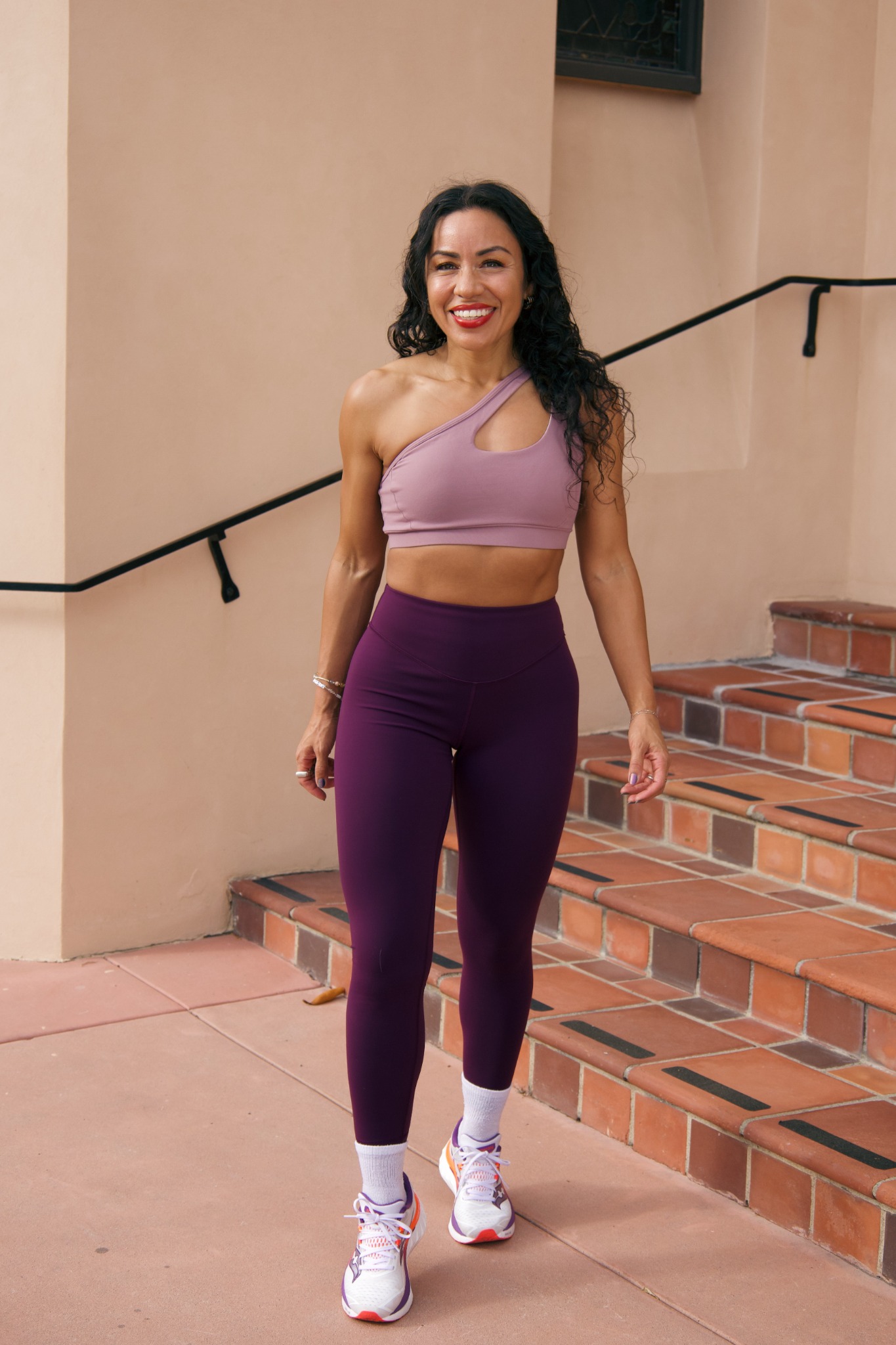 Marissa standing in plum activewear